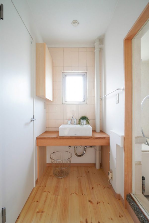 洗面台の下は配管をかくしながらタオルや衣類を収納できるスペースに。壁面の収納扉を開くと鏡が現れます。