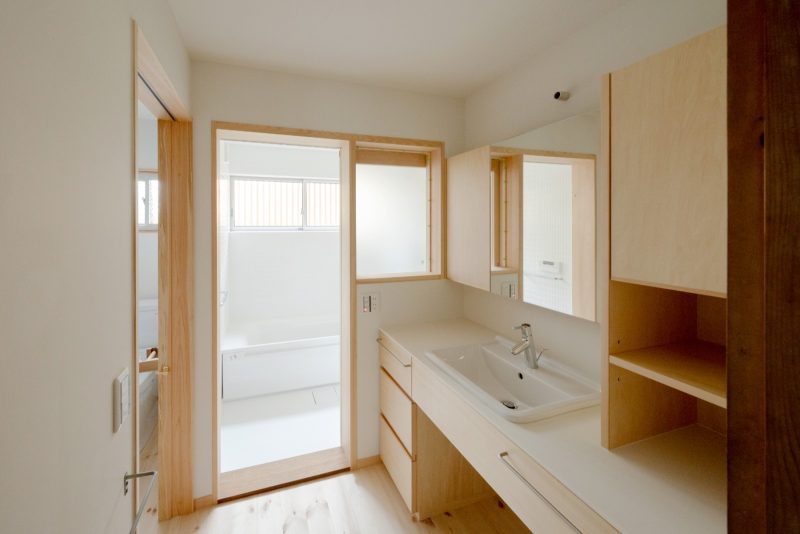 浴室は窓側を増築し以前より広く使えるようになりました。洗面所の建具も木跡 宮鍋圭さんが製作。水回りの壁や天井は白を基調としているため明るい印象に。
