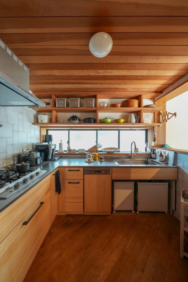 キッチンは木目を基調とした全体に馴染むデザインのものに。センスが光るキッチンツールが空間を彩ります。大小様々の組み合わせが面白いタイルは奥様が色んなタイルのショールームに足を運び選んだものです。