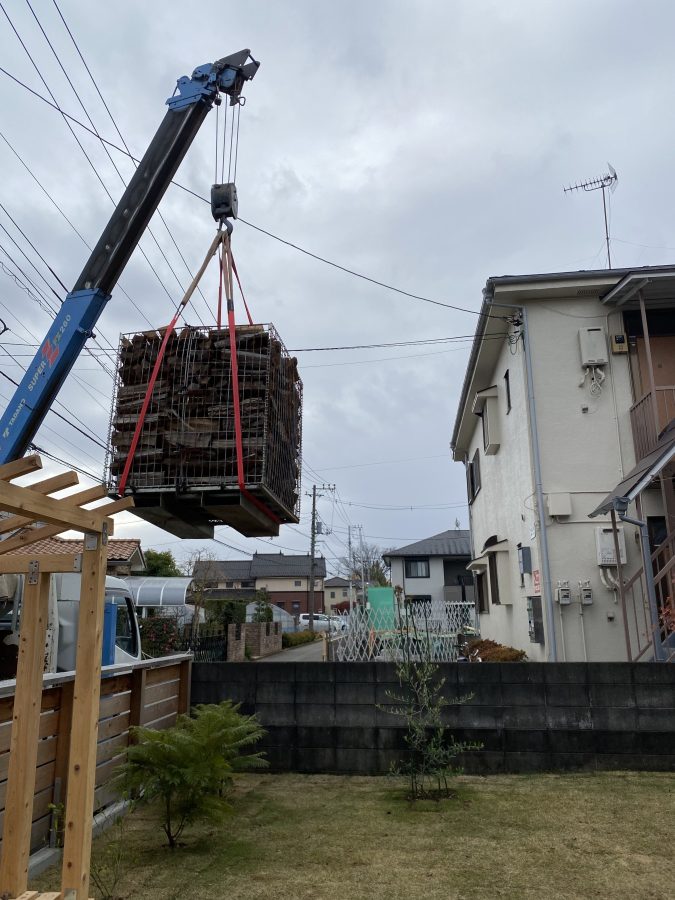 クレーンでパレットを庭に運んでもらいます